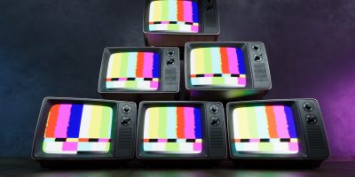 Stack of Vintage retro television on dark wooden background