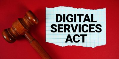 Digital Services Act text written on rip paper with wooden judgment gavel on red background